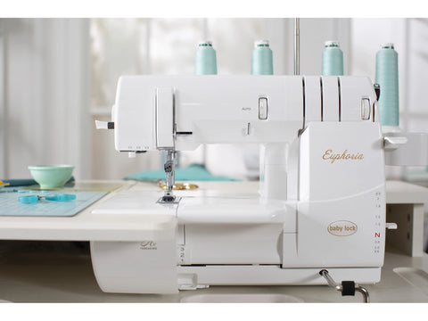 White Baby Lock Euphoria cover stitch serger with light blue thread spools.