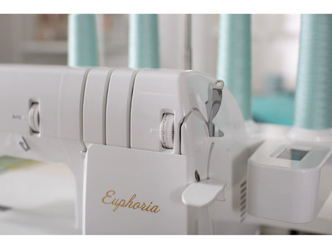 A white Baby Lock Euphoria cover stitch serger with light blue thread spools.