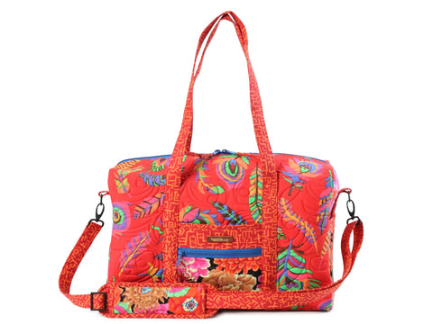 Red quilted duffle bag with colorful feather patterns and a shoulder strap.