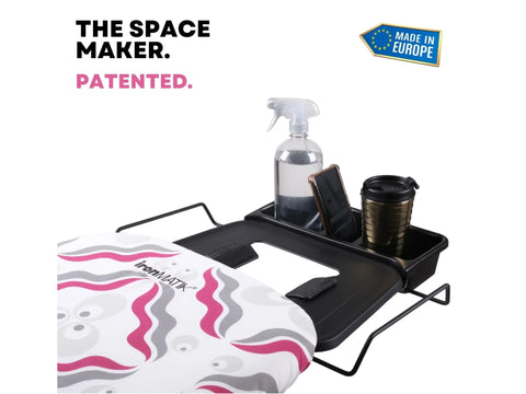 A black ironing board with a purple and gray patterned cover, featuring an attached accessory tray.