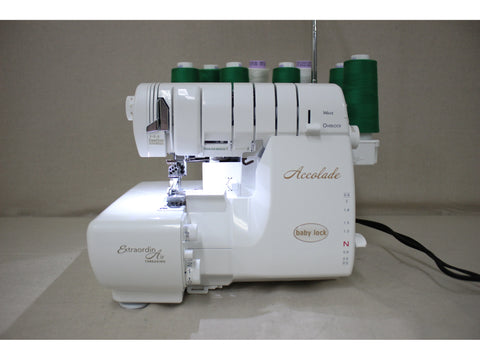 A white Baby Lock Accolade serger with green and white thread spools.