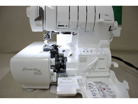A white Baby Lock Accolade serger is shown with its front cover open, revealing threading instructions.