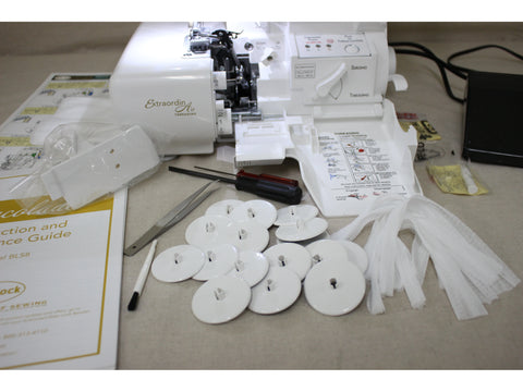 A white Baby Lock Accolade serger with its cover open, surrounded by accessories.