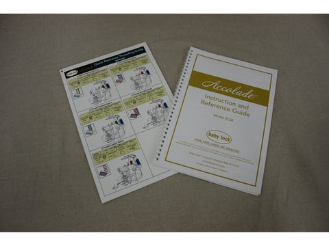 Two Baby Lock Accolade instruction manuals are displayed on a textured surface.