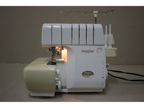 A white and beige Baby Lock Imagine 2 serger with visible threading mechanisms.