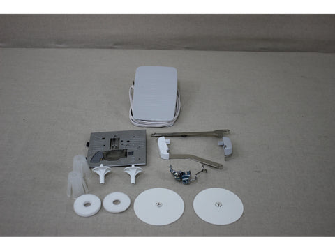 Sewing machine accessories including a foot pedal, needle plate, and various attachments.
