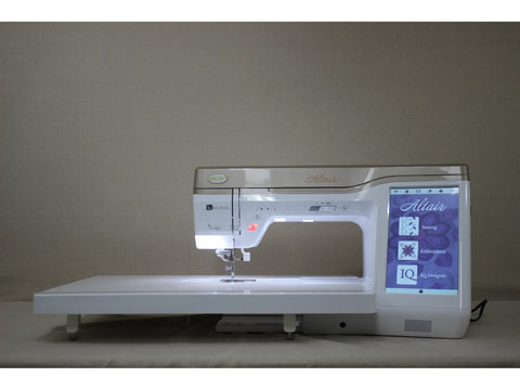 A white Baby Lock Altair sewing and embroidery machine with a lit screen.