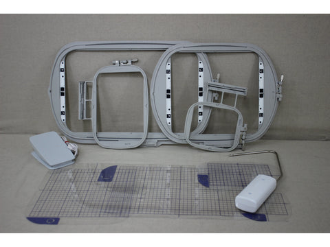 A collection of grey embroidery hoops, a foot pedal, and a clear grid ruler.