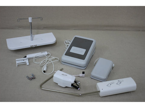 A collection of white Baby Lock sewing machine accessories and components.