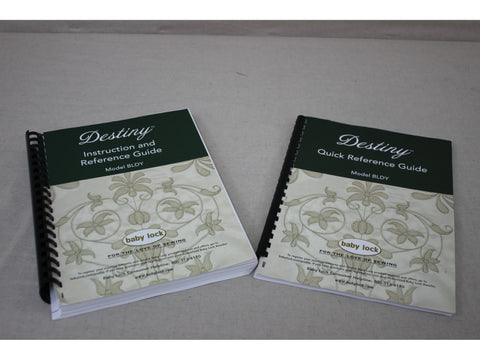Two Baby Lock Destiny instruction manuals with green covers and floral designs.