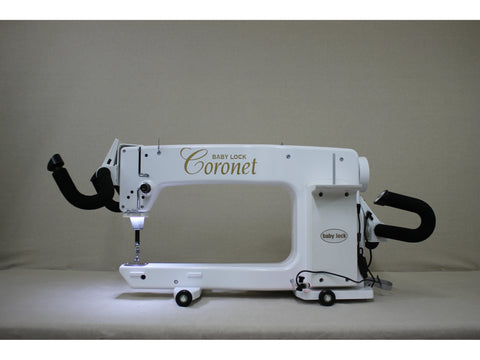 A white Baby Lock Coronet longarm quilting machine with a 5ft frame.