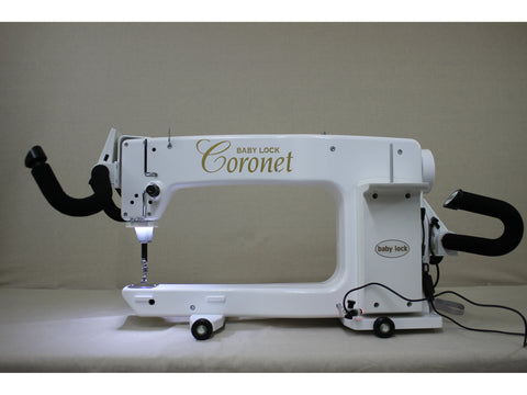 A white Baby Lock Coronet longarm quilting machine with a 5ft frame.