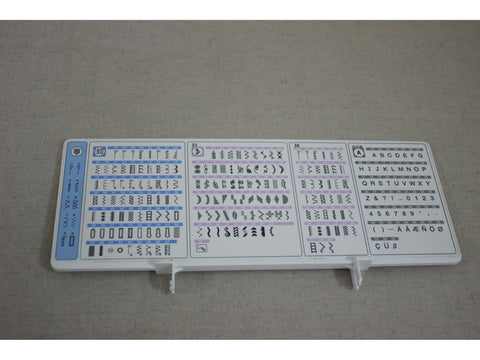 A white sewing machine stitch guide displays various stitch patterns and an alphabet.