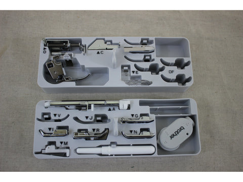 A white plastic case holds various metal sewing machine feet and accessories.