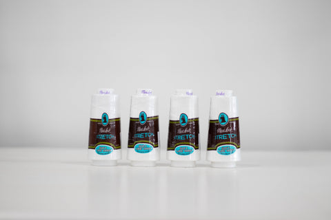 Four white spools of Maxi-Lock Stretch serger thread are arranged in a row.
