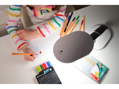 Daylight Foldi Go Rechargeable Table Lamp illuminating a child drawing.