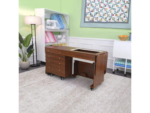 A brown sewing cabinet with an electric lift and storage drawers on wheels.