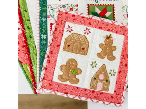 A quilted Christmas wall hanging features gingerbread men and houses with candy cane borders.
