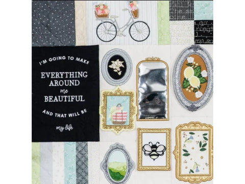 A quilt featuring a bicycle, framed pictures, and an embroidered quote.