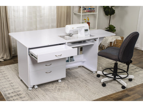 A white sewing and companion chest with an open drawer, a sewing machine, and a chair.