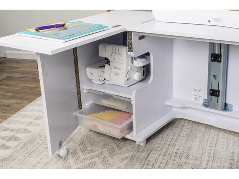 White sewing cabinet with a sewing machine, cutting mat, and fabric storage.