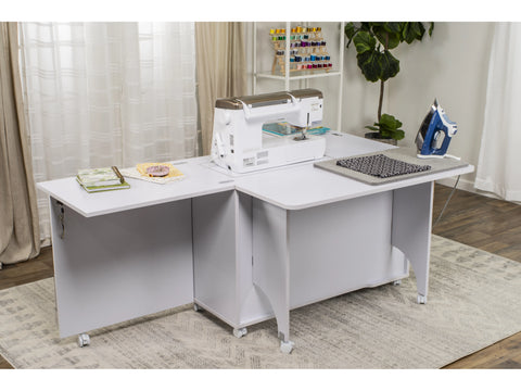A white sewing cabinet with a sewing machine, ironing board, and supplies on a rug.