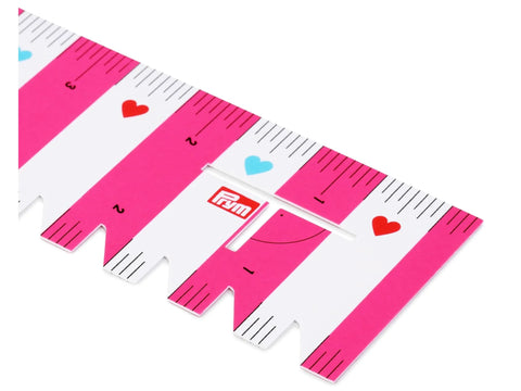 Pink and white striped Prym Love ruler with heart accents.