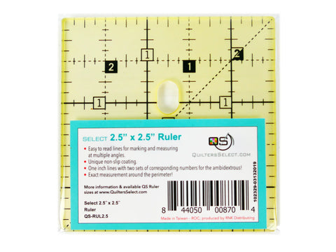 A clear 2.5 by 2.5 inch quilting ruler with black markings and a label.