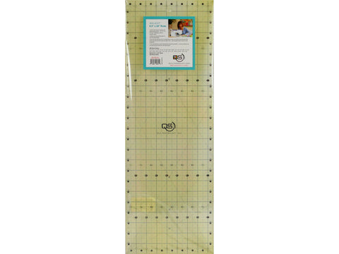 A clear 8.5" x 24" quilting ruler with a blue label showing product features and a woman quilting.