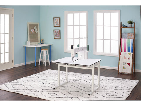 A Baby Lock Regent 18" Sit Down Quilting Machine is set up in a bright sewing room.