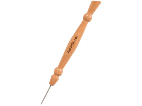 A wooden stiletto and pressing tool with "ByAnnie.com" printed on the handle.