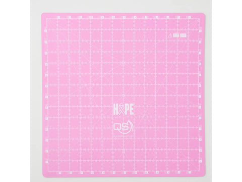 A pink 14x14 inch cutting mat with a grid, numbers, and "HOPE" logo.