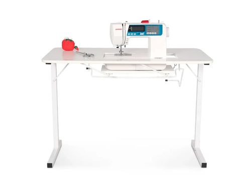 White Arrow Gidget I sewing table with a sewing machine, pin cushion, and scissors.