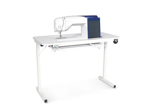 White sewing machine on a white folding table with a blue side panel.
