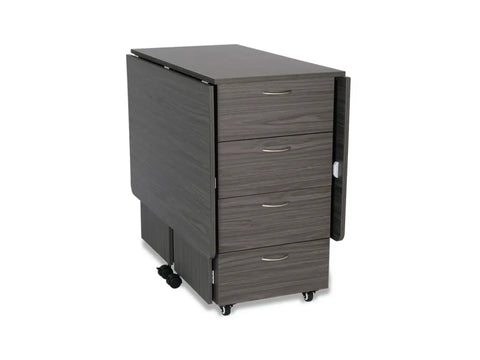 A dark gray wooden cutting table with four drawers and two folded leaves on wheels.