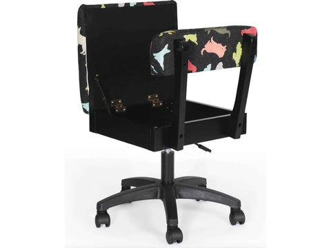 Black hydraulic sewing chair with a colorful dog pattern and open storage.