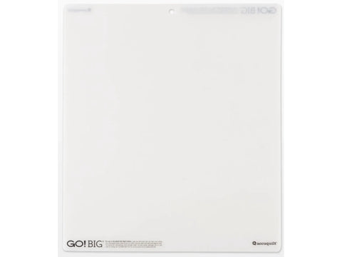 A white AccuQuilt GO! Big cutting mat, 14 by 16 inches, with a hole at the top.