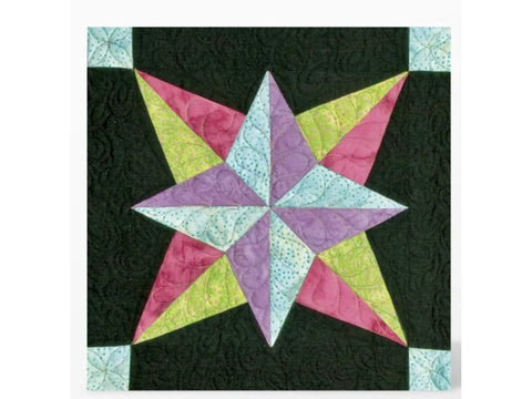 A quilted block features a colorful star design on a black background.