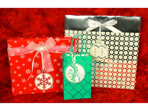 Three Christmas gift bags and a wrapped present with Mylar Christmas ornaments.