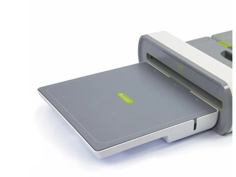 An AccuQuilt GO! Big Die Catcher, a gray tray with a green logo, extends from a white and gray cutting machine.