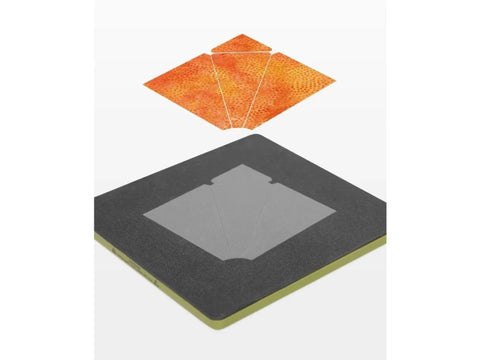 A fabric cutting die and the orange fabric pieces it cuts for a crossed canoes quilt block.