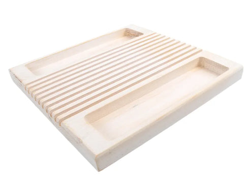 A light wood quilter's ruler holder with parallel slots and two open trays.