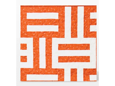 Orange and white quilt with a geometric pattern.