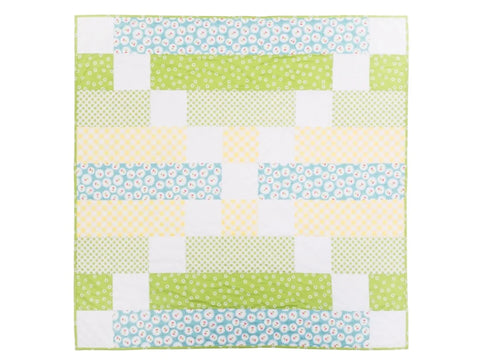 A colorful quilt with a checkerboard pattern of green, yellow, and blue fabrics.
