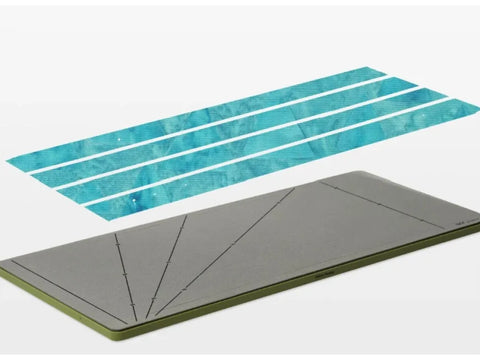 AccuQuilt GO! Strip Cutter die with four blue fabric strips above it.