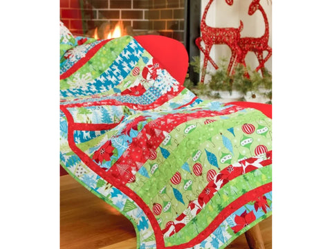 A colorful Christmas-themed quilt with red, green, and blue patterns draped over a red chair.