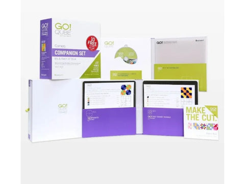 A collection of AccuQuilt Qube Companion Corners 10" quilting tools and instructional materials.