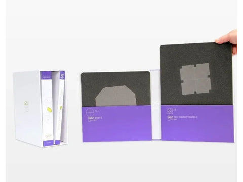 A person holds a black and purple AccuQuilt Qube Companion Corners 10" set.