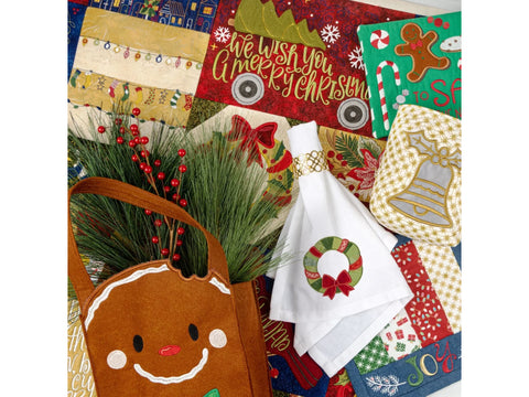 A flat lay of various Christmas-themed embroidered fabric items, including a quilt, towels, and a gingerbread man bag.