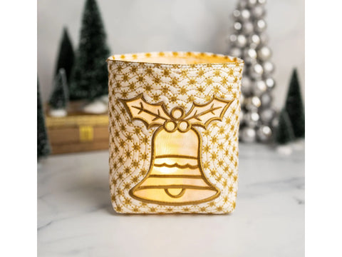 A white fabric lantern with gold embroidered snowflakes and a glowing Christmas bell design.